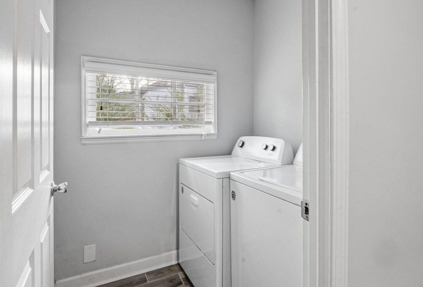 Laundry area featuring dark wood-type flooring and independent washer and dryer