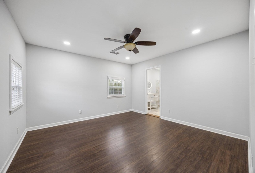 Unfurnished bedroom with dark wood-type flooring, ceiling fan, recessed lighting, and ensuite bathroom