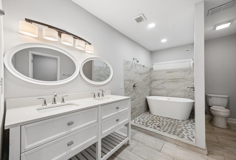 Bathroom with a soaking tub, double vanity, and recessed lighting