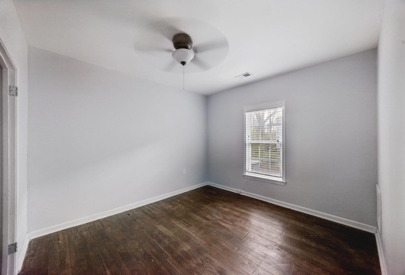 Spare room with dark wood finished floors and a ceiling fan