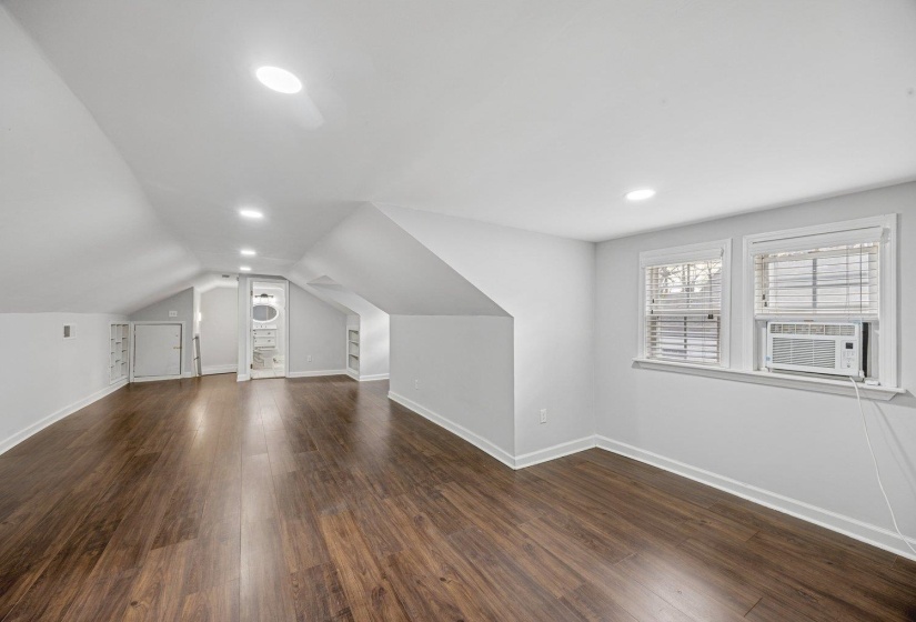 Bonus room with dark wood-style floors, vaulted ceiling, and recessed lighting