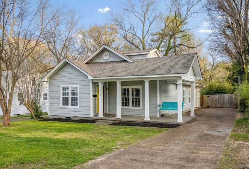 View of front of house with covered porch, a shingled roof, concrete driveway, and a gate