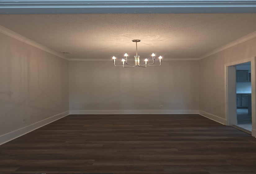 Dining space featuring a polished chrome chandelier, crown molding, and wood-finish flooring
