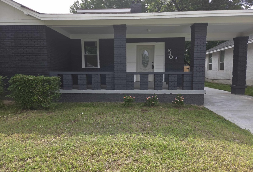Brick exterior with a covered front porch and carport