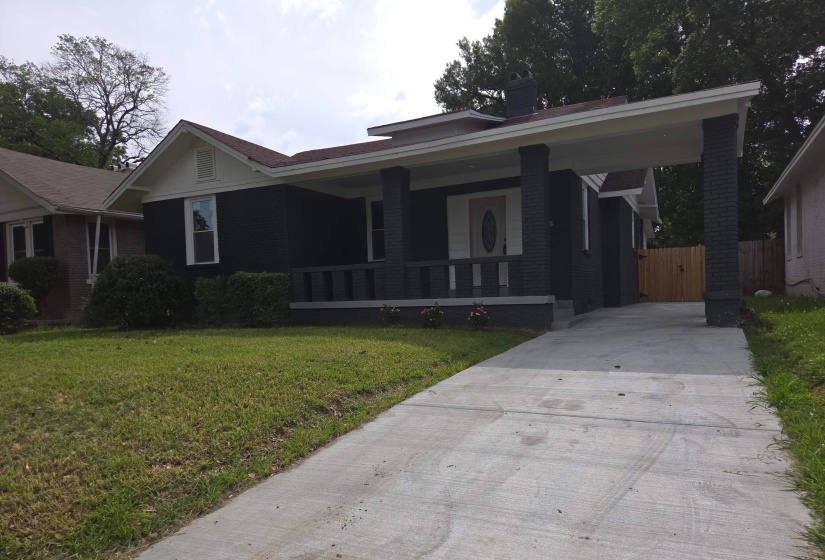 Exterior showcasing a dark-painted brick facade, a portico with square columns, and a light-colored entry door