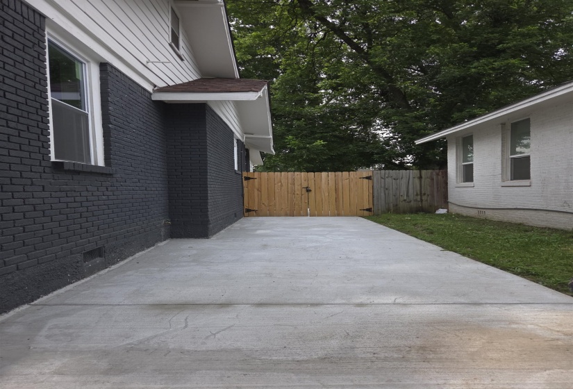 Concrete side yard with a full privacy fence