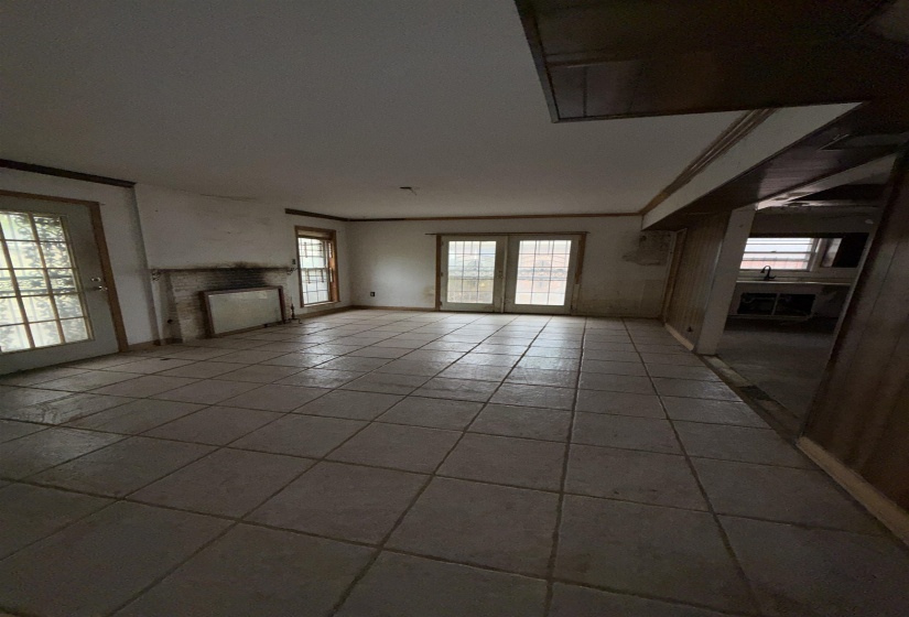 Unfurnished living room featuring a fireplace, crown molding, and light tile patterned flooring