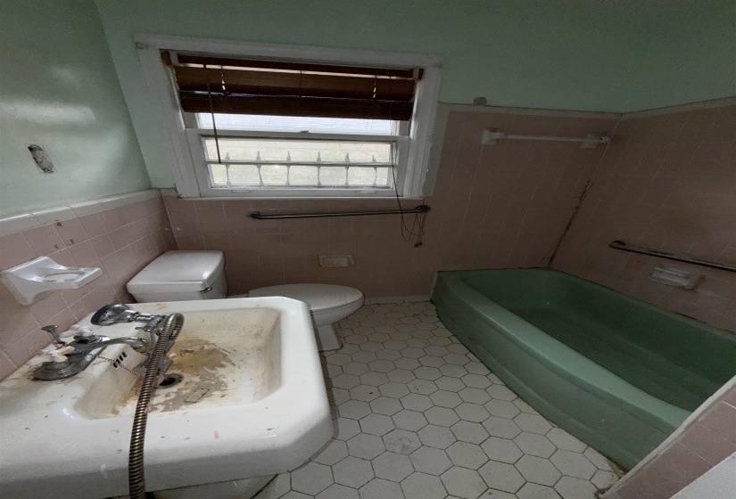 Full bath featuring a bathtub, wainscoting, tile walls, and a shower