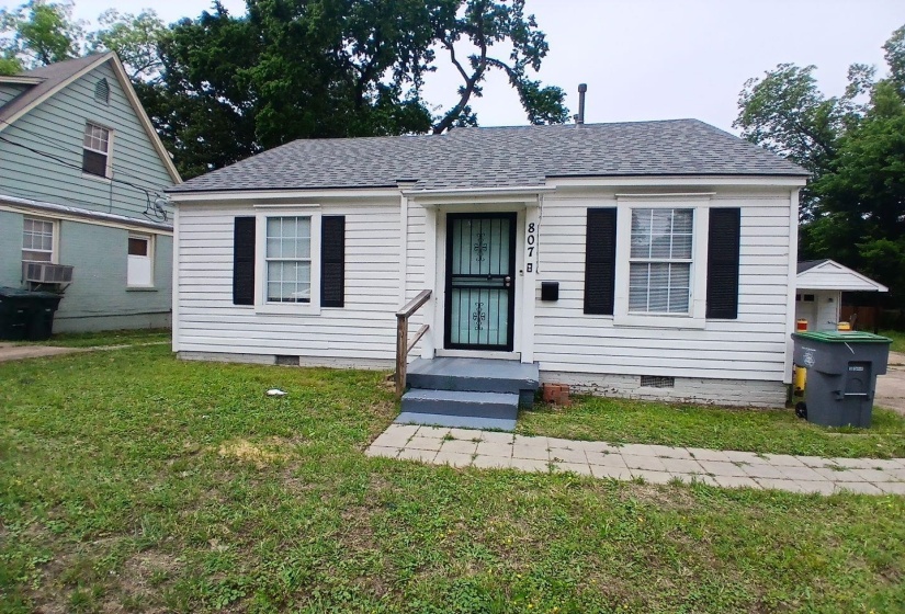 White siding exterior with black shutters and a complementary black security screen door