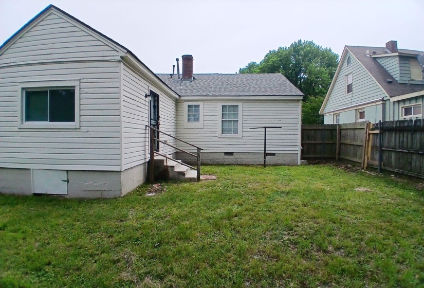 Expansive rear yard featuring an exterior door with steps and handrails