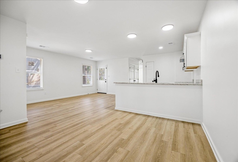Bright living area featuring wood-finish flooring, recessed lighting, and white walls