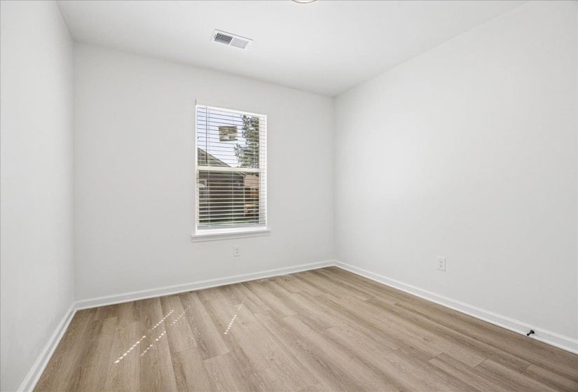 Interior room featuring light wood-finish flooring, white walls, and a recessed ceiling light