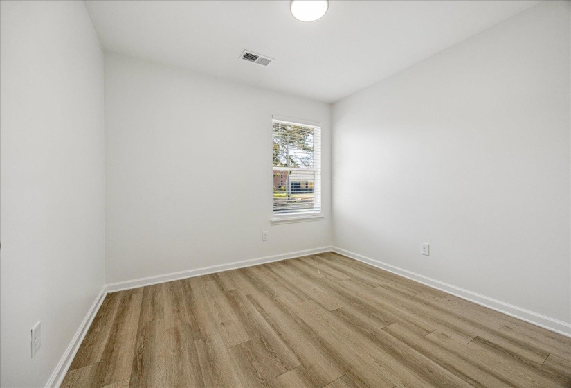 Neutral color palette featuring wood-finish flooring, white walls, and bright overhead lighting