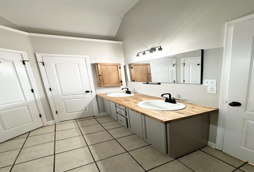 Dual vanity with wood-finish countertop, undermount sinks, and matte black fixtures