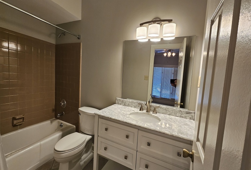 Bathroom featuring a white vanity with a marble-finish countertop, undermount sink, and brushed nickel faucet