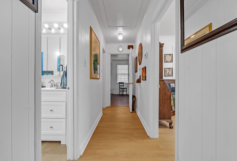 Hallway featuring wood-finish flooring and white vertical paneling