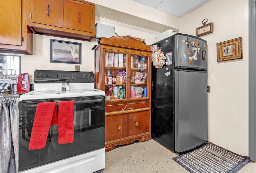 Kitchen featuring a white electric range, refrigerator, and wood-finish cabinetry