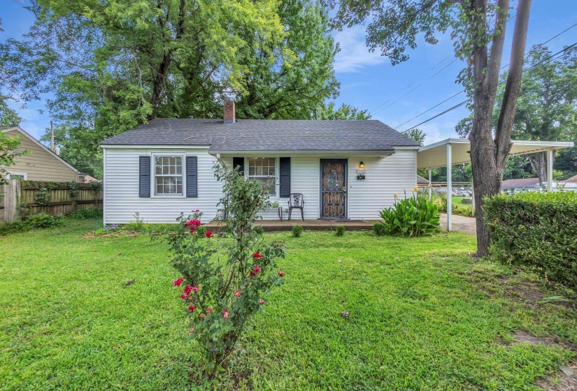 Charming white siding exterior with dark blue window shutters, a front porch, and an attached carport