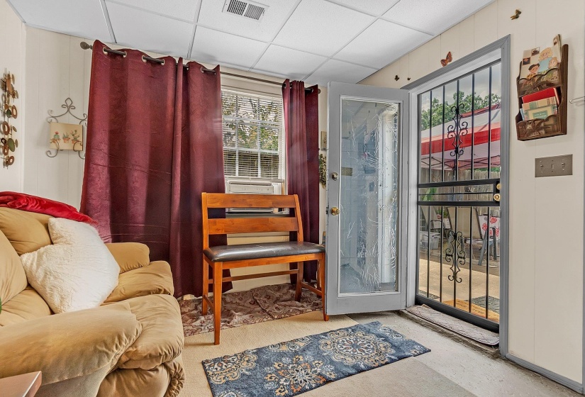 Entryway featuring a security screen door, paneled walls, and a drop ceiling