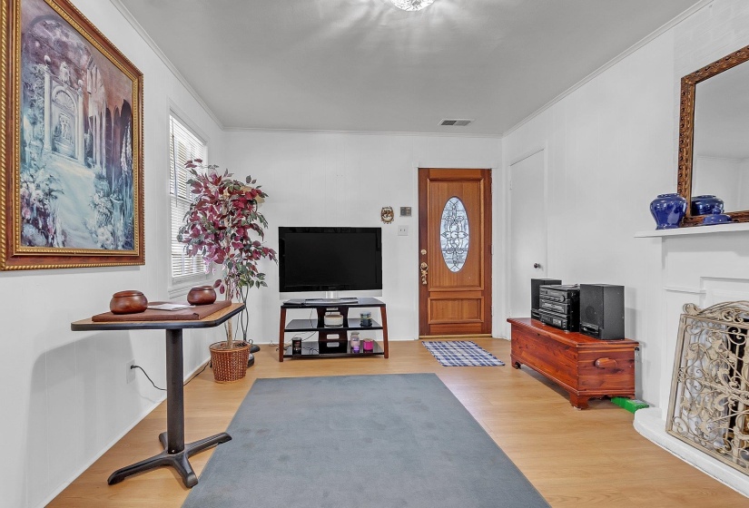Living space featuring wood-finish flooring, white walls, and crown molding