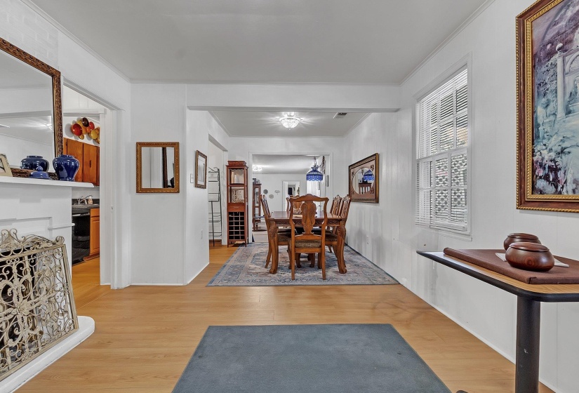 Bright interior room featuring light-toned wood-finish flooring, white painted walls, and white crown molding