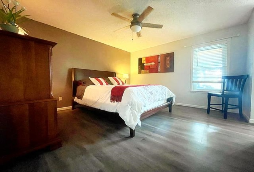 Bedroom with a textured ceiling, ceiling fan, and wood-type flooring