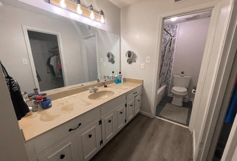 Full bathroom featuring vanity, shower / bathtub combination with curtain, wood-type flooring, and toilet