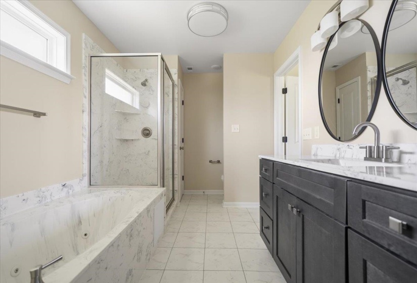 Bathroom featuring a dual-sink vanity with dark wood cabinetry and stone countertops