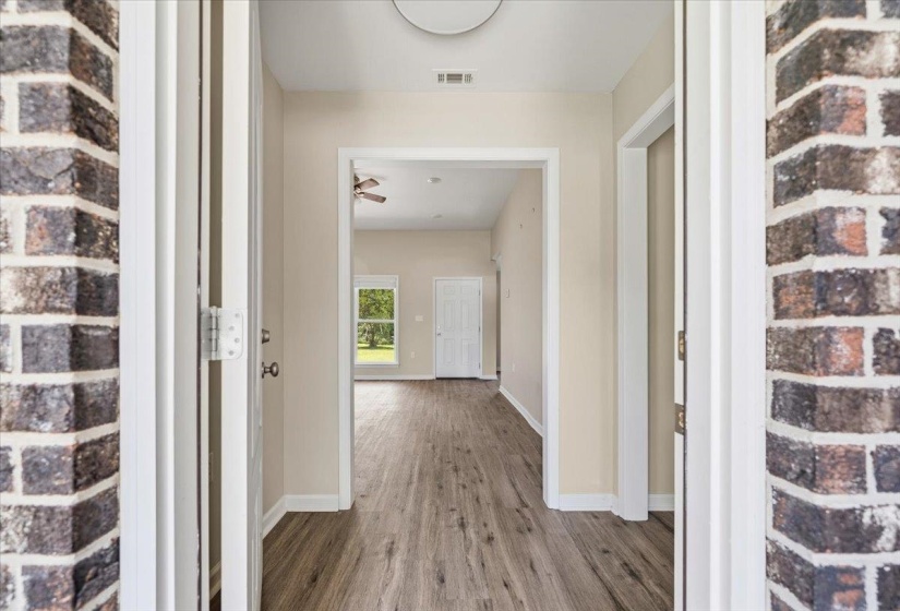 Entryway featuring brick surround, wood-finish flooring, and light neutral wall tones