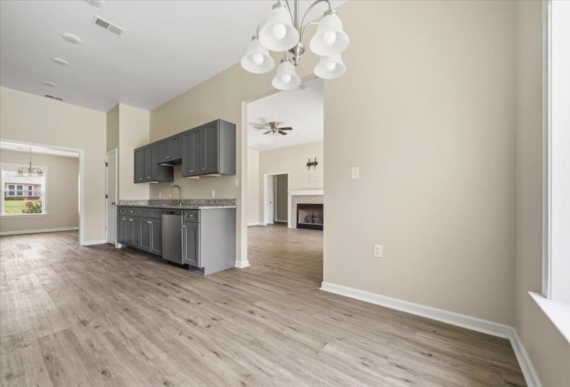 Modern kitchen area featuring dark gray cabinetry, light-toned countertops, and stainless steel appliances