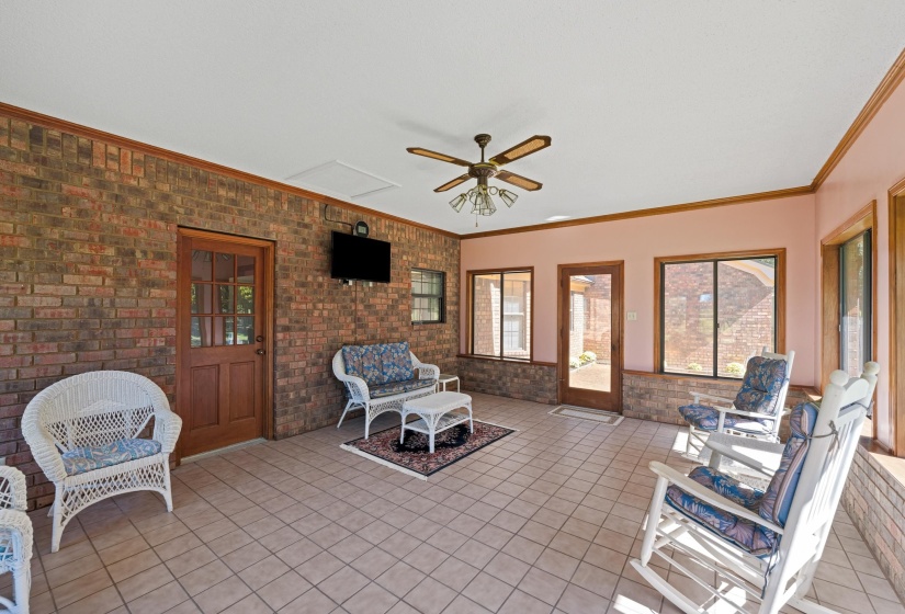 Spacious tiled sunroom offering panoramic views of the surrounding countryside—the perfect place to enjoy morning coffee or unwind while taking in peaceful sunsets.