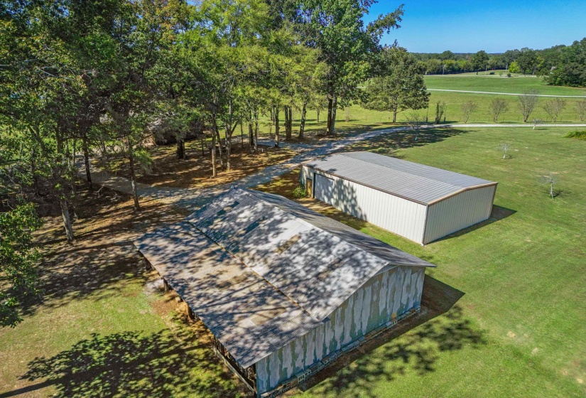 Large workshop with electricity and concrete flooring alongside a barn with covered lean-to, providing exceptional space for equipment, hobbies, storage, or animals.