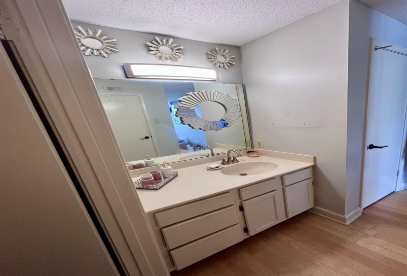 Bathroom vanity with an integrated sink, brushed nickel faucet, and a large wall-mounted mirror