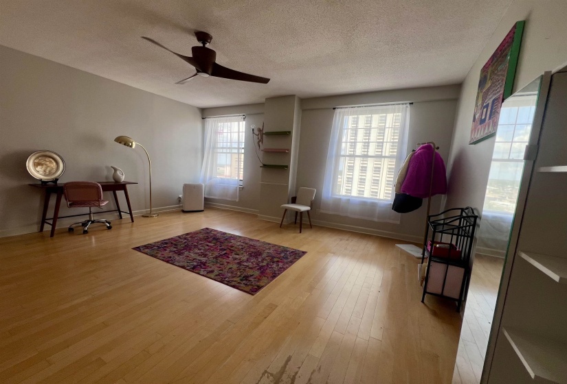 Light wood-finish flooring with a ceiling fan overhead