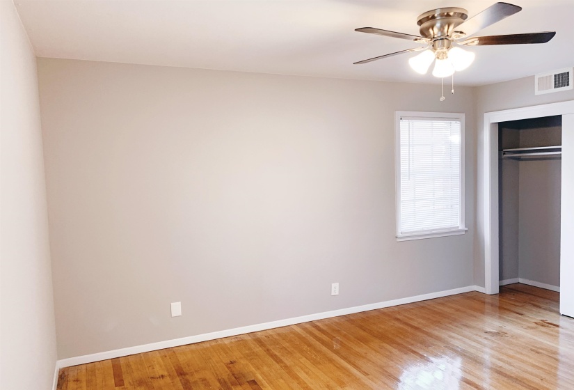 Unfurnished bedroom with light wood-style flooring, a closet, and a ceiling fan