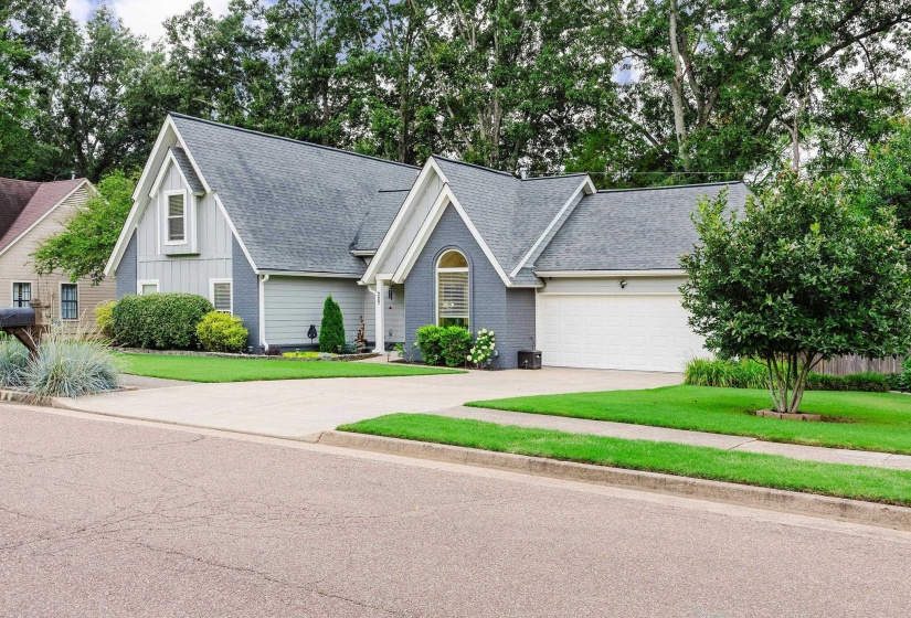 Single-family residence featuring a two-car garage, pitched shingle roof, and a paved driveway