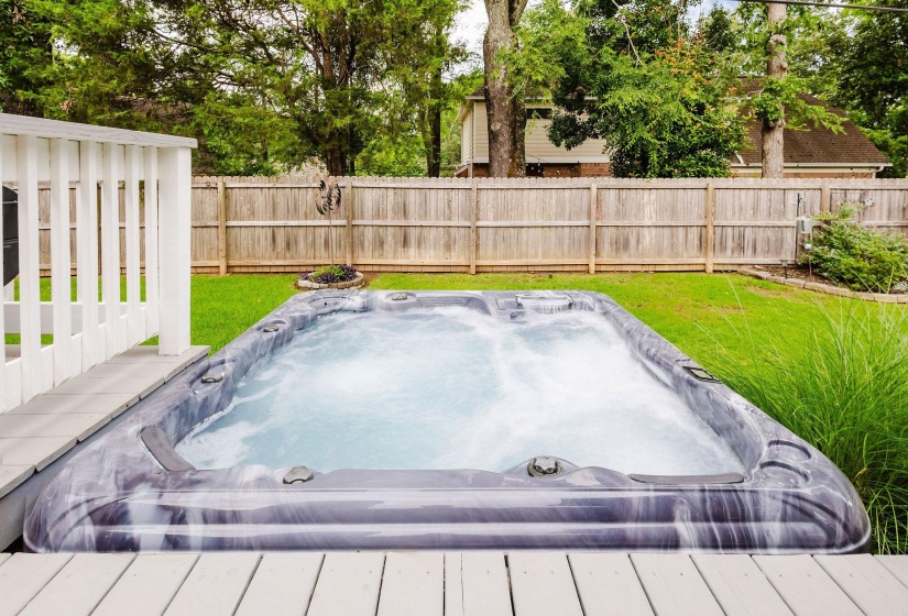 Backyard featuring an integrated hot tub and an expansive wooden deck