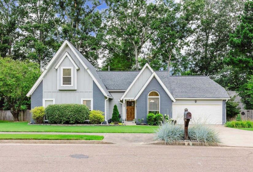 Gray-painted brick and light gray siding exterior with a dark asphalt shingle roof