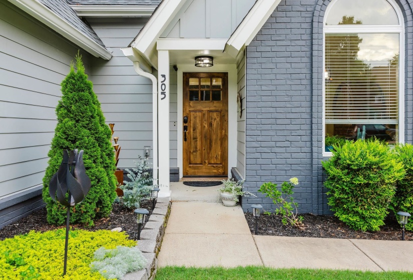 Wood-paneled front door with sidelights and an overhead fixture