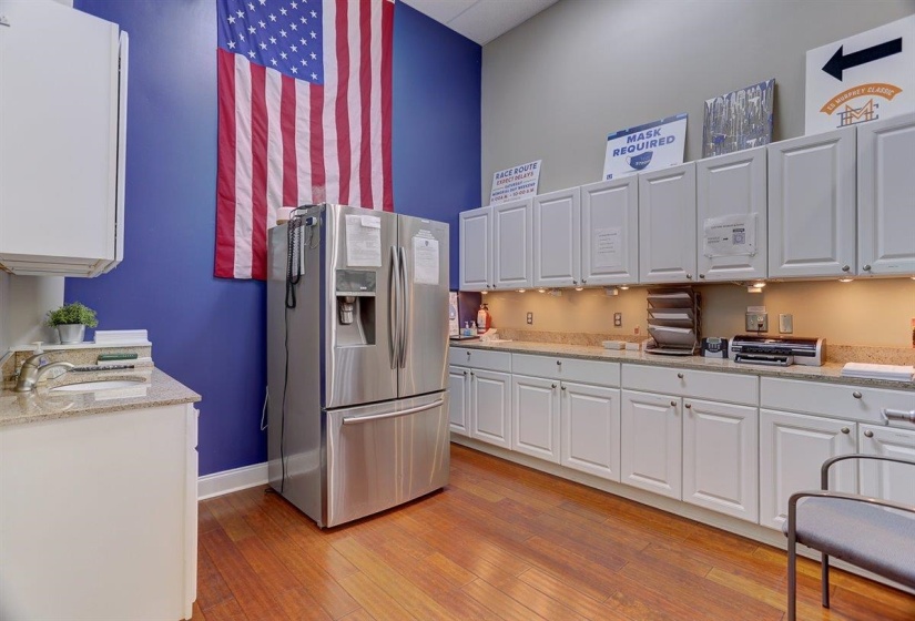 Kitchen featuring white cabinetry, stainless steel fridge, a sink, and light wood finished floors