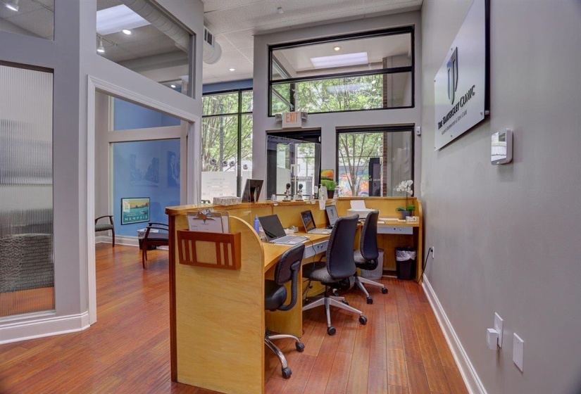 Office space featuring baseboards, a high ceiling, wood finished floors, and visible vents