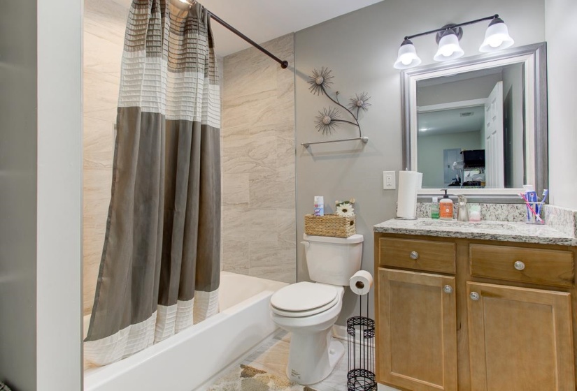 Bathroom with vanity and shower / tub combo with curtain. Located downstairs by laundry room