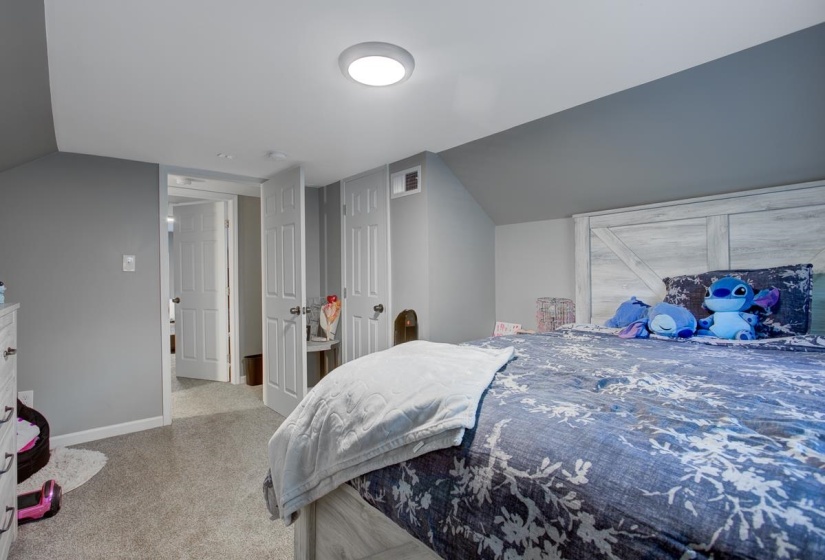Bedroom with light colored carpet. Upstairs