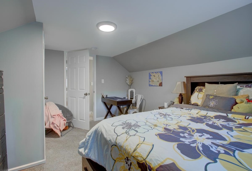 Bedroom with light colored carpet. Upstairs