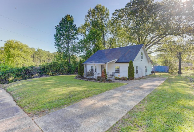 View of front of property with a porch, a front yard, driveway, and a shingled roof