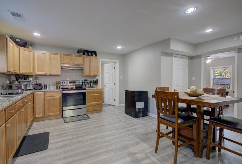 Kitchen featuring stainless steel electric range oven, light LVP flooring, recessed lighting, light stone countertops, and ceiling fan