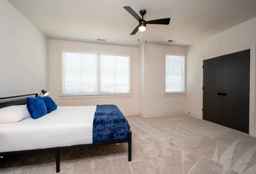 Bright interior space featuring light-toned carpeting and multiple windows with blinds