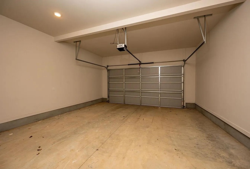 Single-bay garage featuring an automatic overhead door opener and light-toned walls