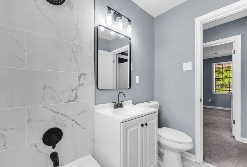 Bathroom featuring a white vanity with panel cabinetry, a rectangular sink, and matte black hardware
