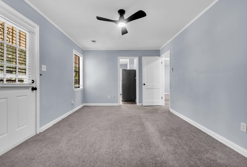 Spacious room featuring light gray carpeting, light blue walls, and white trim